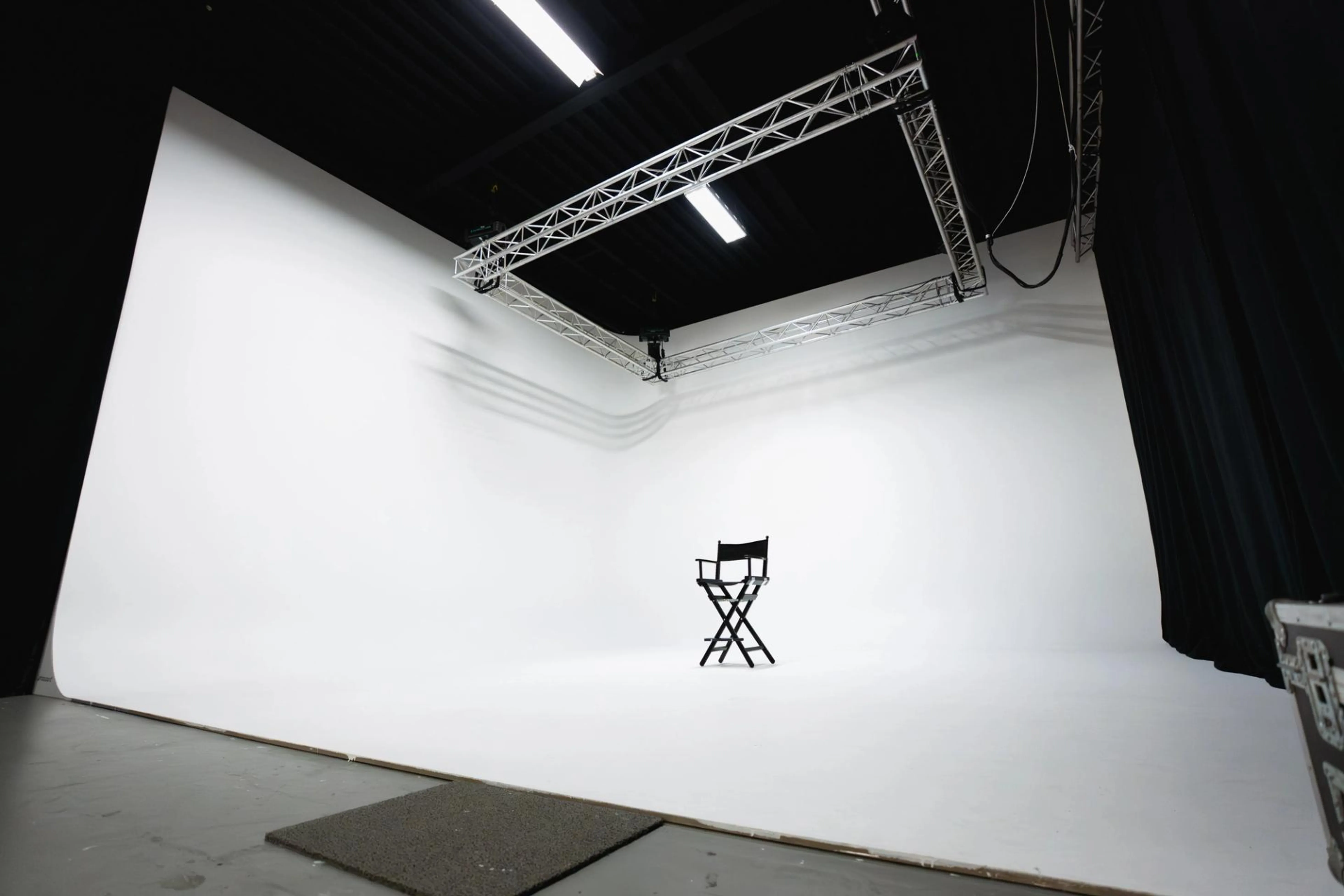 Professionele cyclorama studio in Amsterdam met grote witte infinity wall, gemotoriseerd truss-systeem en volledig uitgeruste productieruimte voor foto- en videoproducties.